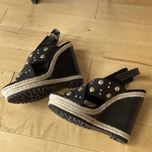 Black wedge shoes with rope and gold-tone stud details.